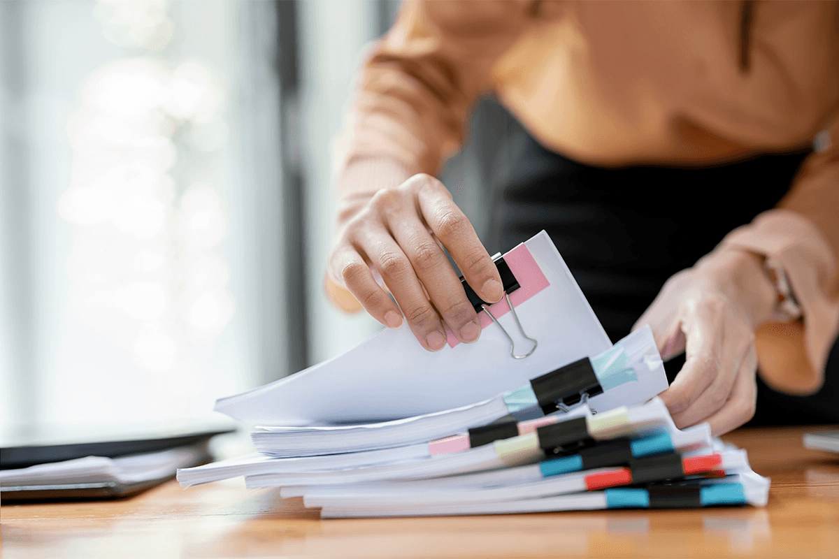 Hands sorting labelled documents into a folder