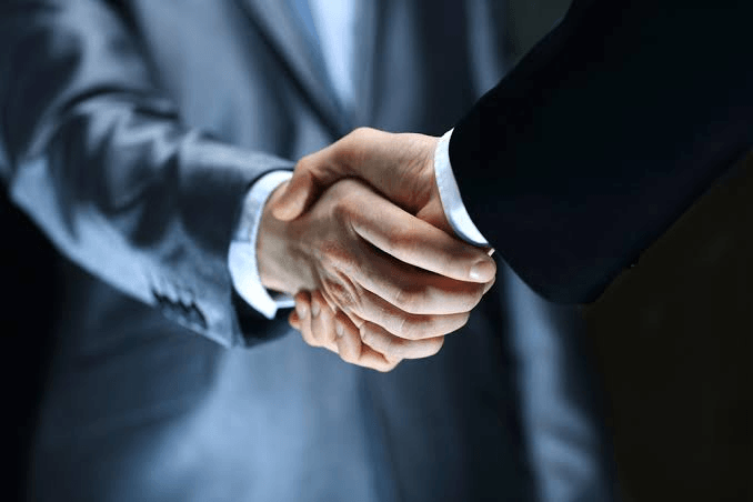 Two people in business dress shaking hands